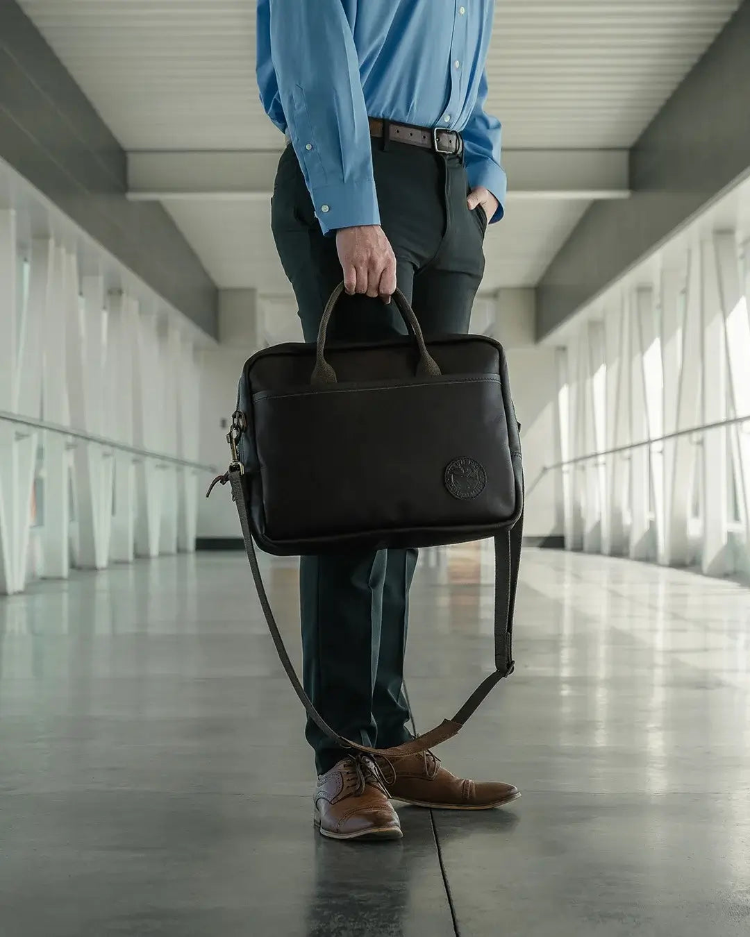 The Innovator Briefcase being carried by a man in a hallway