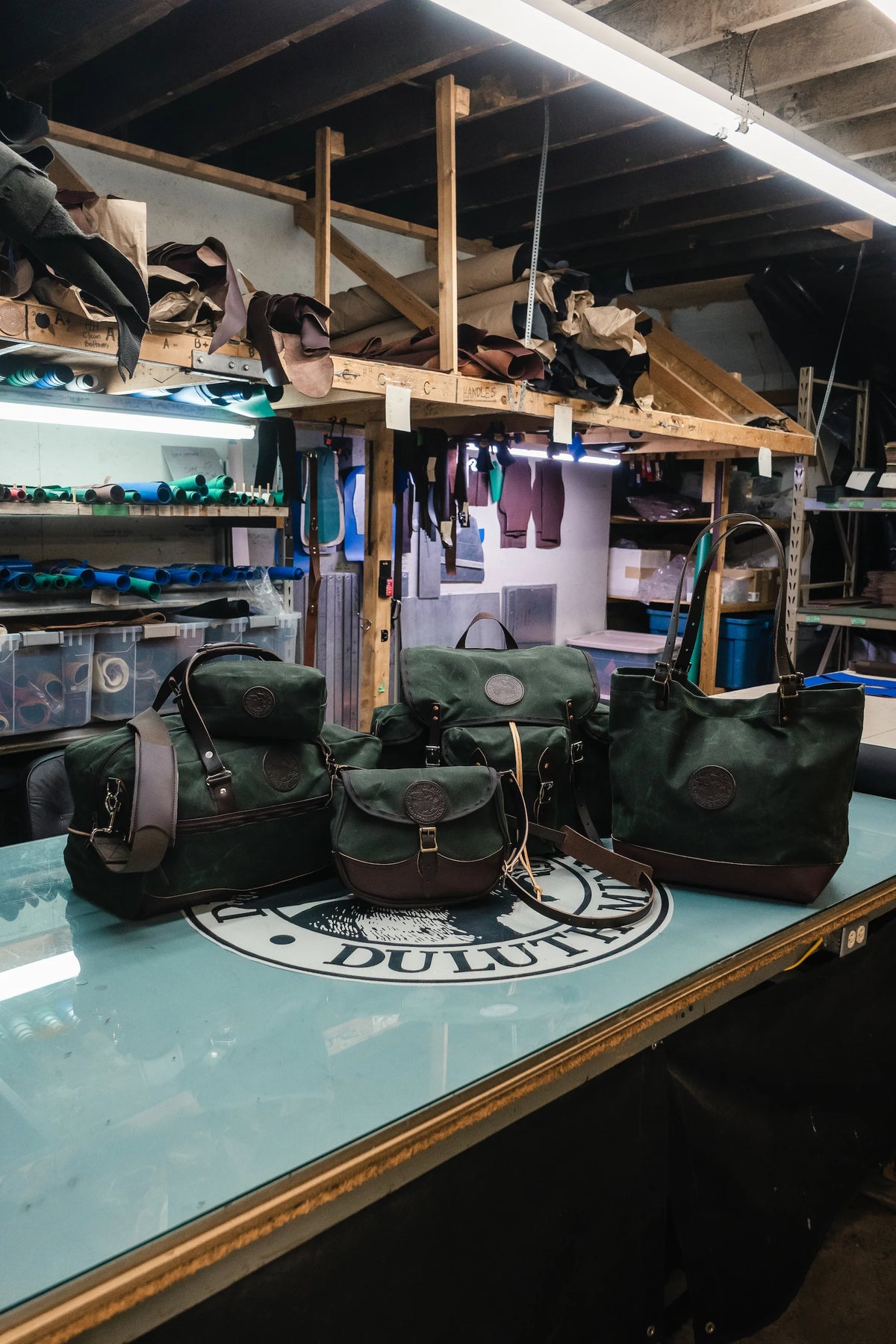 A group image of the new Duluth Pack Gitchi Gami Collection in waxed olive drab waxed canvas and full grain cowhide leather. 