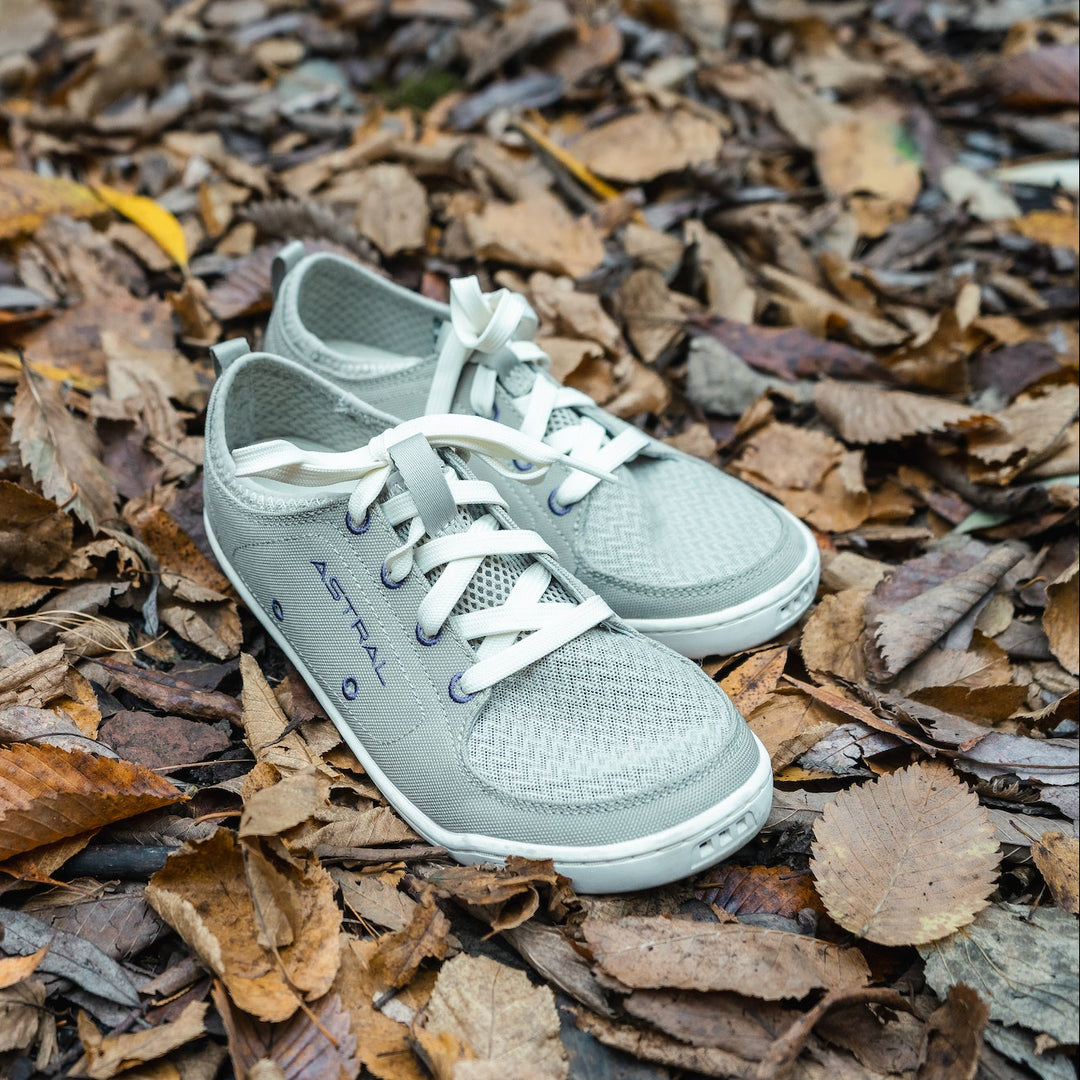 Image of a pair of taupe loyak astral barefoot shoes on a bed of colorful leaves. 
